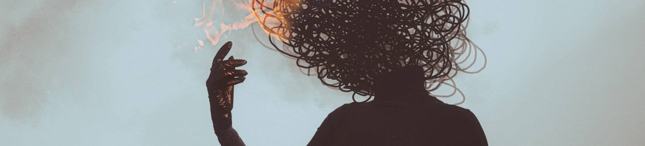 Silhouette of a person sitting on the floor with a scribble-like head engulfed in flames.