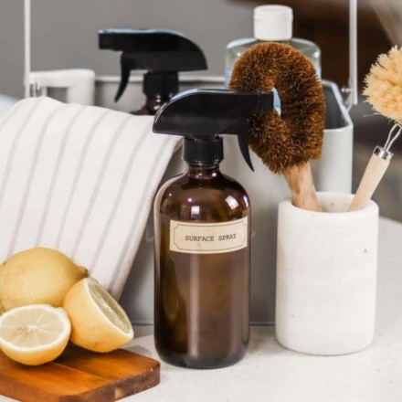 A kitchen countertop with a brown spray bottle labeled 