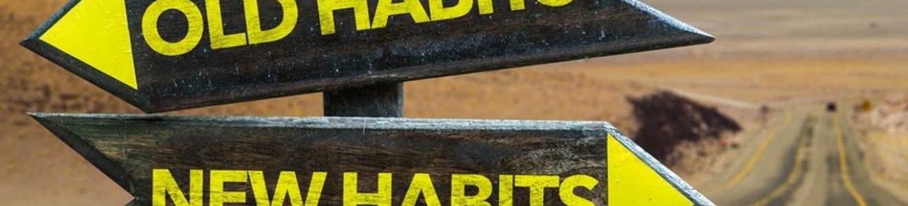 Wooden signpost at a desert road intersection pointing left to 
