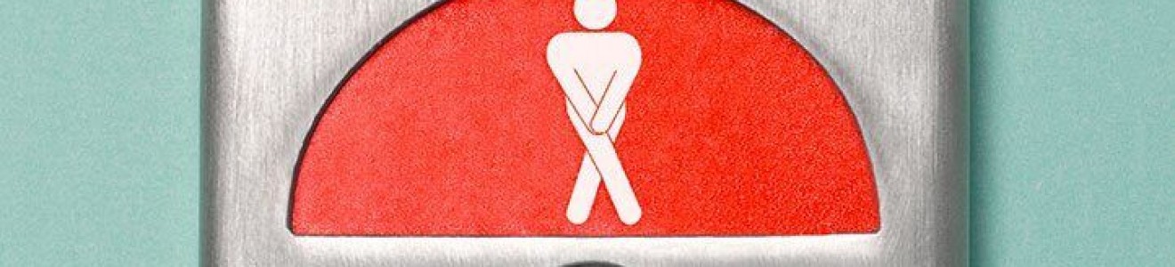 A metallic panel with a red indicator showing a person icon in a crossed leg position, suggesting urgency or needing to use the restroom.