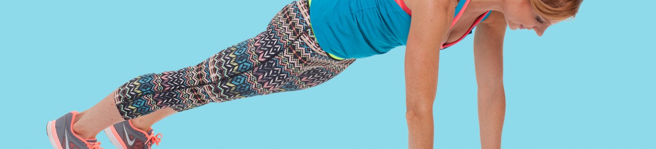 A woman in athletic wear is performing a plank exercise against a blue background.