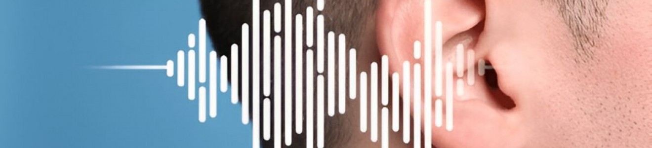 Close-up of a person's ear with a digital soundwave graphic overlaying it against a blue background.